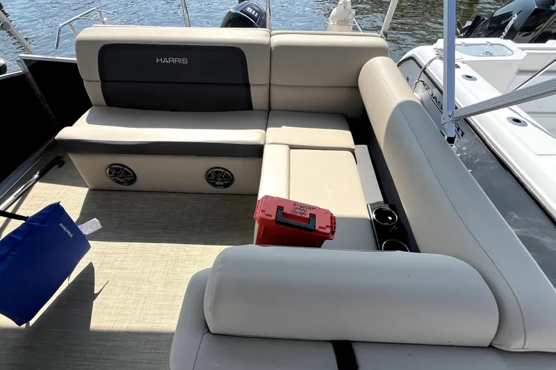 Slide: The Image of 2025 Harris HCX23 boat interior with beige seating and storage compartments. - 7