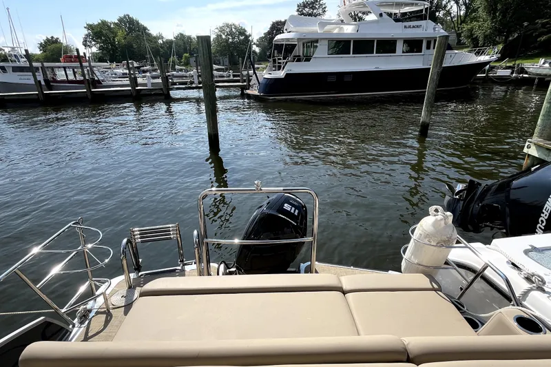 Slide: The Image of Rear view of a 2025 Harris HCX23 boat docked at a marina. - 8