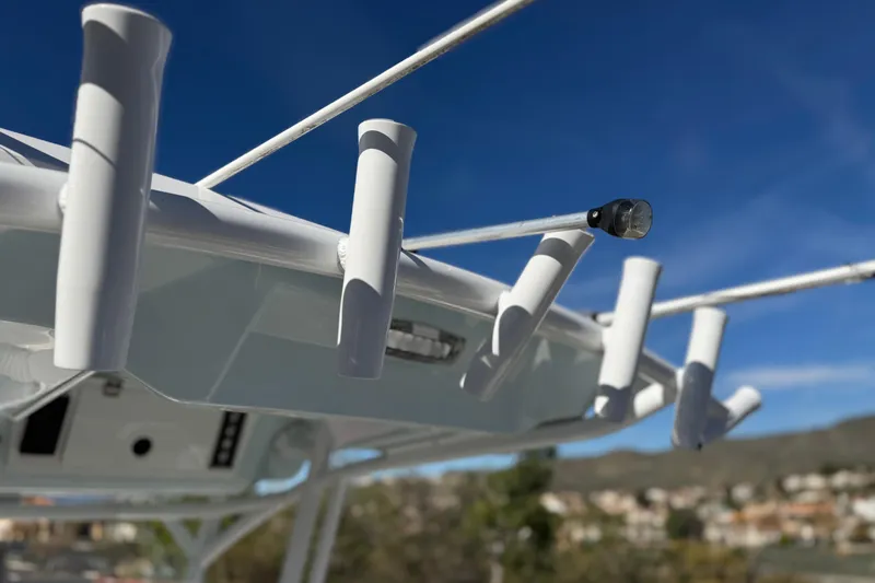 Slide: The Image of 2021 Sea Fox 268 Commander boat with rod holders against a clear blue sky. - 29