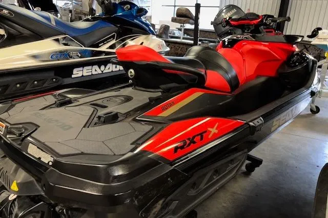 Slide: The Image of 2020 Sea-Doo RXT-X 300 jet ski in a showroom, featuring a sleek red and black design. - 8