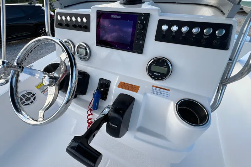 Slide: The Image of 2024 Robalo 206 Cayman boat dashboard with steering wheel and electronic controls. - 14
