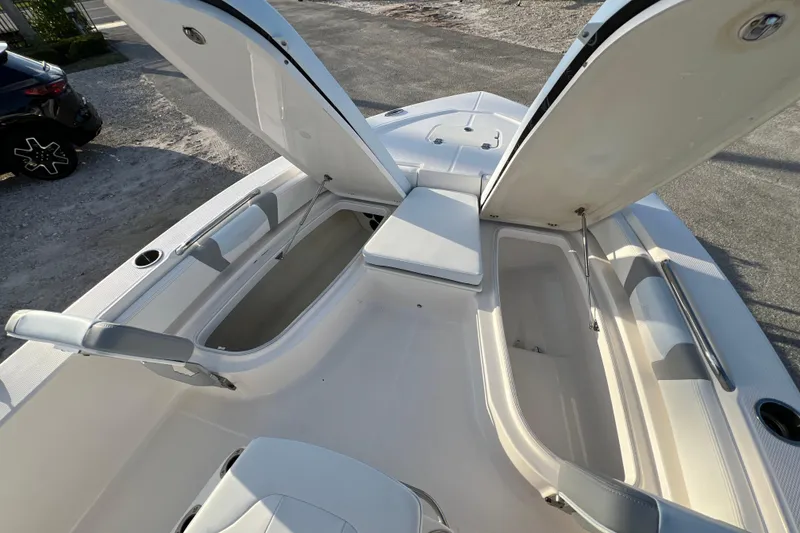 Slide: The Image of 2024 Robalo 206 Cayman boat with open storage compartments and seating area. - 19