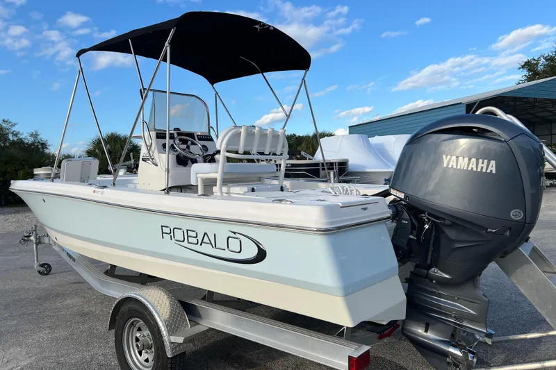Slide: The Image of 2024 Robalo 206 Cayman boat with Yamaha engine on trailer, under blue sky. - 6