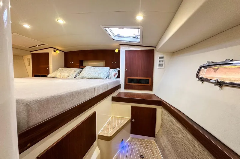 Slide: The Image of Cozy master berth featuring a queen size bed, reading lights, built in shelf headboard, storage lockers, windows, and privacy - 20