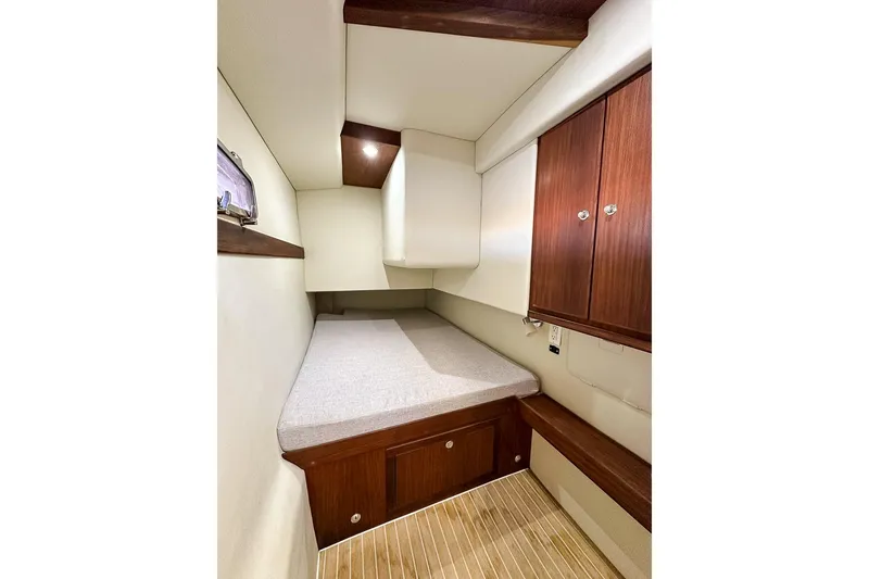 Slide: The Image of Guest berth includes a comfortable twin bed, storage lockers, shelf, and starboard window - 23
