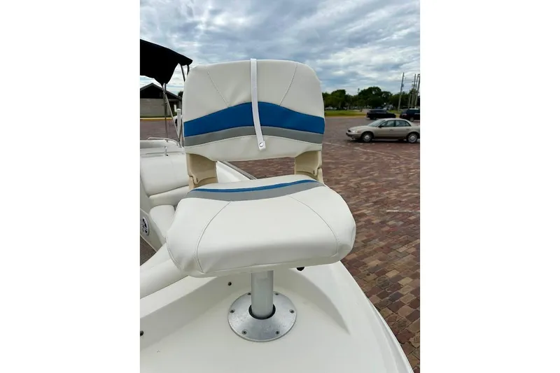 Slide: The Image of White and blue boat seat on 2004 Bennington RL 210, parked on brick pavement. - 10