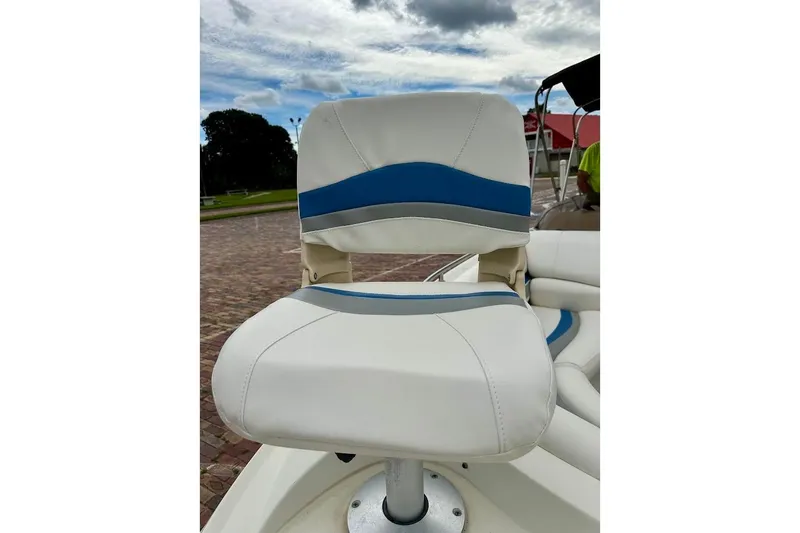 Slide: The Image of White and blue boat seat on a 2004 Bennington RL 210 under cloudy sky. - 11
