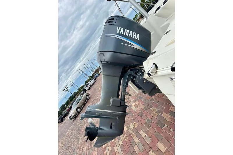 Slide: The Image of Yamaha outboard motor on a 2004 Bennington RL 210 boat, parked on brick pavement. - 14