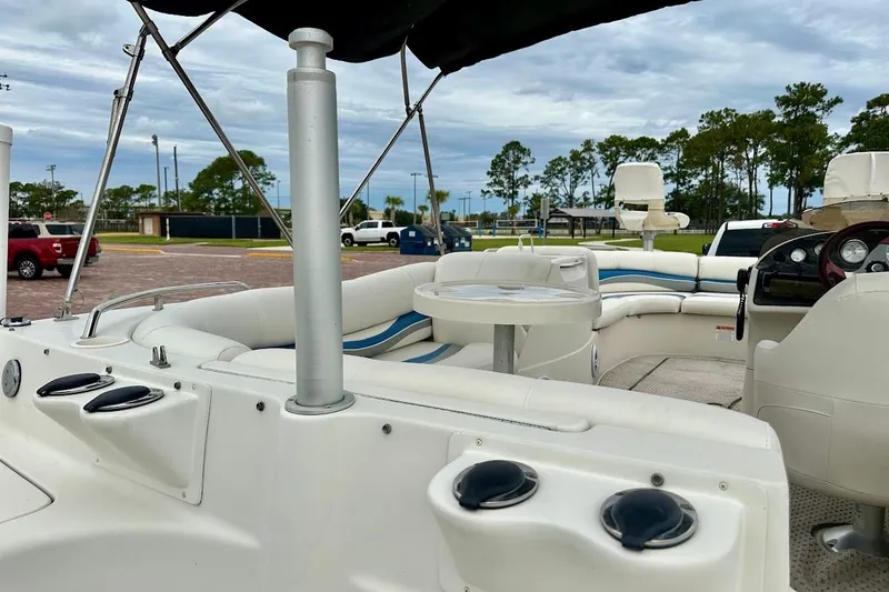 Slide: The Image of 2004 Bennington RL 210 boat interior with seating and table, parked outdoors. - 17