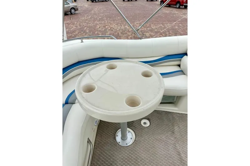 Slide: The Image of 2004 Bennington RL 210 boat interior with round table and cushioned seating. - 19