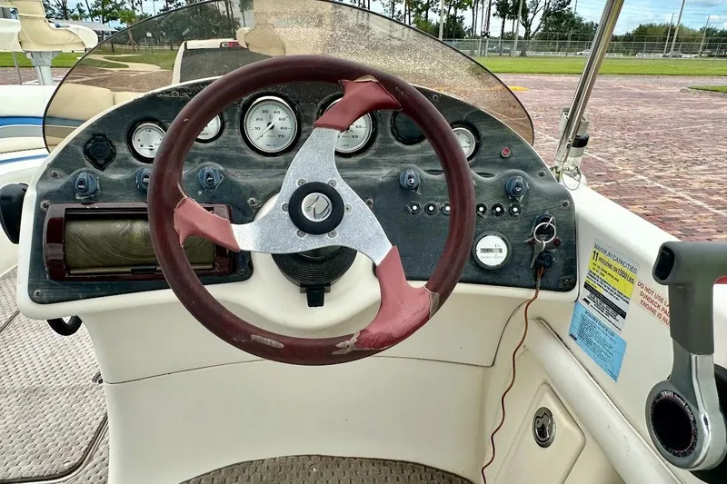 Slide: The Image of 2004 Bennington RL 210 boat dashboard with steering wheel and control panel. - 22