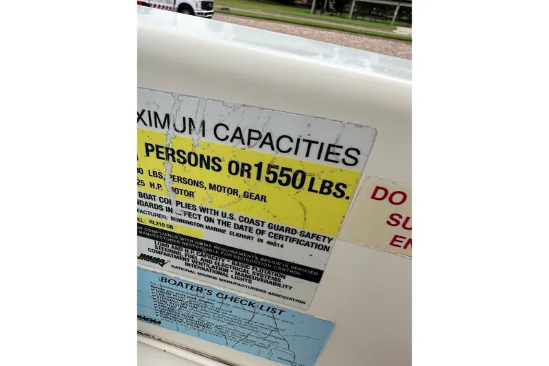 Slide: The Image of Capacity label on 2004 Bennington RL 210 boat, showing weight and person limits. - 24