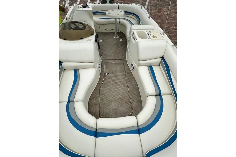 Slide: The Image of 2004 Bennington RL 210 boat interior with white and blue seating, steering console, and table. - 31