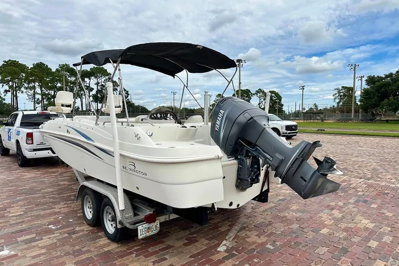 Slide: The Image of 2004 Bennington RL 210 boat on trailer with Yamaha outboard motor, parked outdoors. - 5