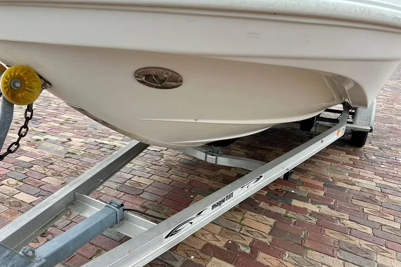 Slide: The Image of 2004 Bennington RL 210 boat on trailer, parked on brick pavement. - 6