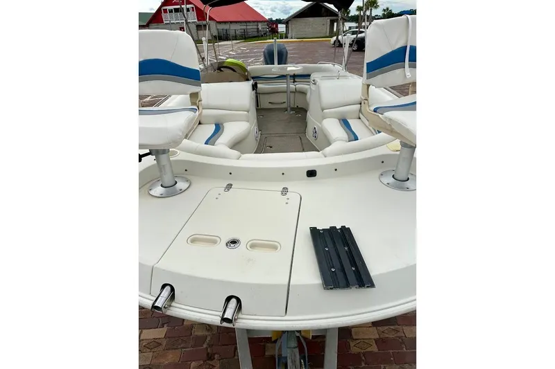 Slide: The Image of 2004 Bennington RL 210 boat interior with white and blue seating, docked outdoors. - 8