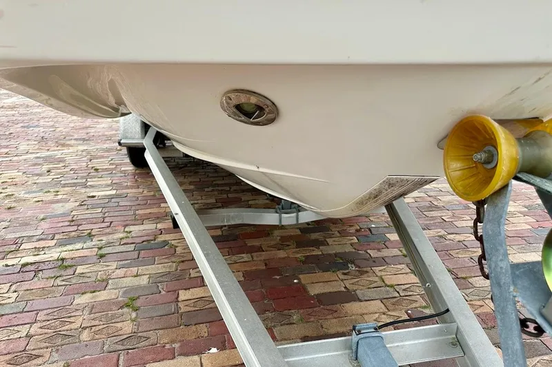 Slide: The Image of 2004 Bennington RL 210 boat on trailer, showing hull and brick pavement. - 9