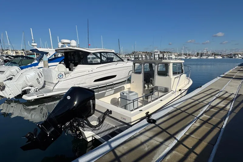 Slide: The Image of 2023 Defiance Admiral 220 EX boat docked at a marina under clear blue skies. - 13