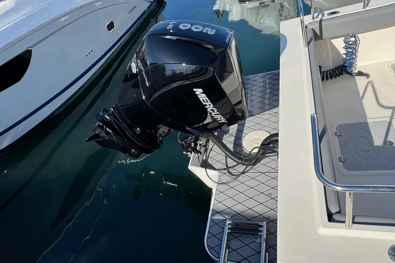 Slide: The Image of 2023 Defiance Admiral 220 EX with Mercury outboard engine, docked on calm water. - 17