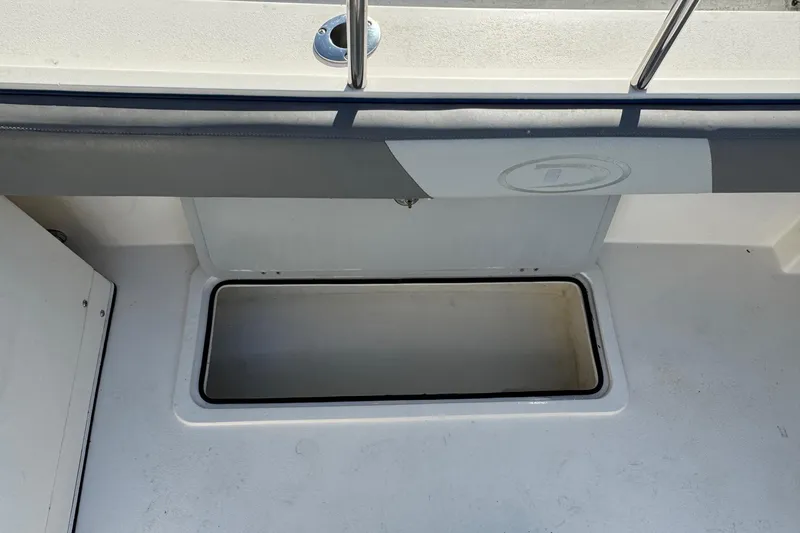 Slide: The Image of 2023 Defiance Admiral 220 EX boat storage compartment, open and empty. - 23