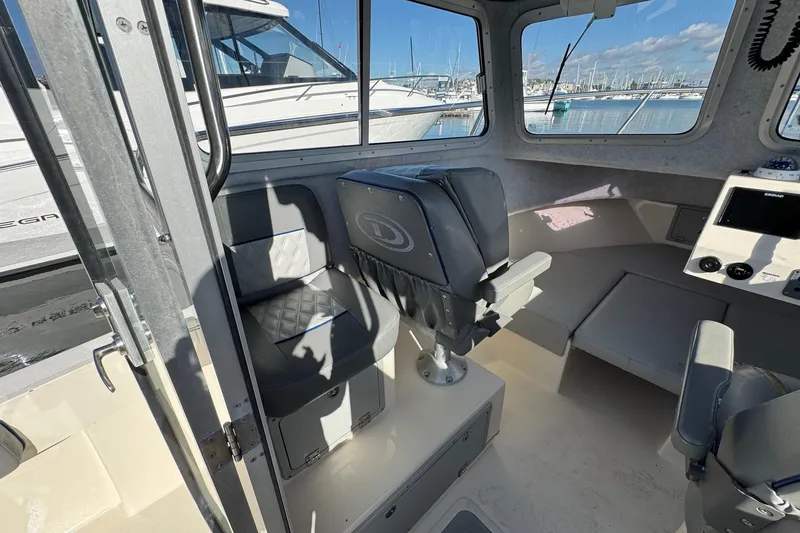 Slide: The Image of Interior of 2023 Defiance Admiral 220 EX boat with seating and control panel. - 35