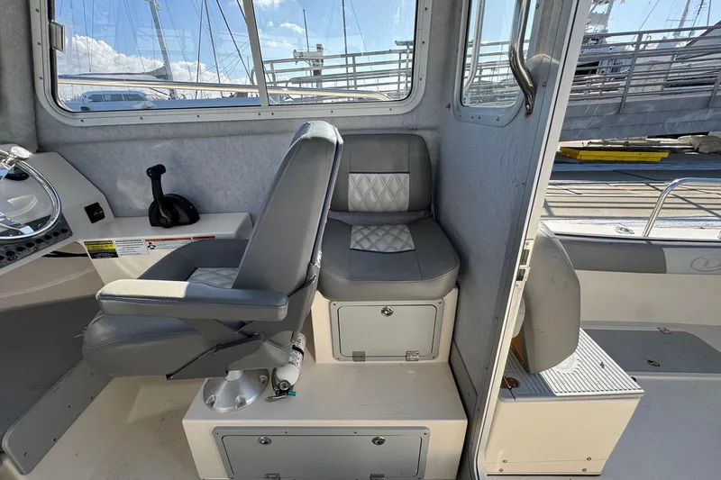 Slide: The Image of Interior of 2023 Defiance Admiral 220 EX boat with gray seating and control panel. - 36