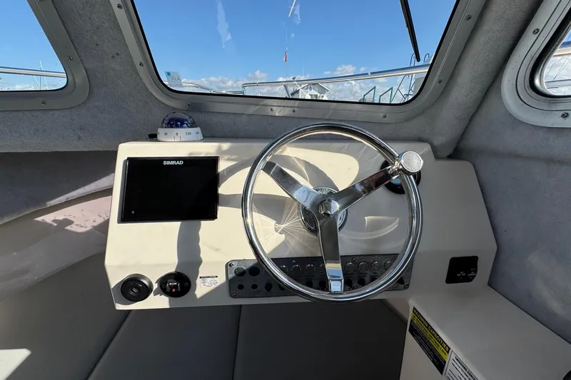 Slide: The Image of Helm of 2023 Defiance Admiral 220 EX boat with steering wheel and navigation display. - 44