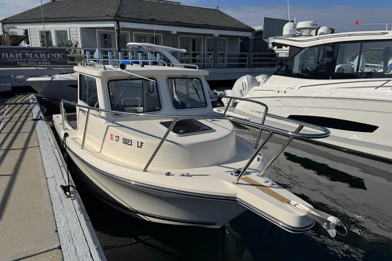 Slide: The Image of 2023 Defiance Admiral 220 EX boat docked at marina, sunny day. - 48