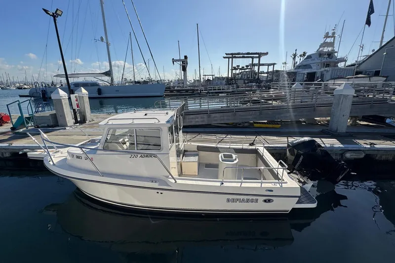 Slide: The Image of 2023 Defiance Admiral 220 EX boat docked at a marina under clear skies. - 5