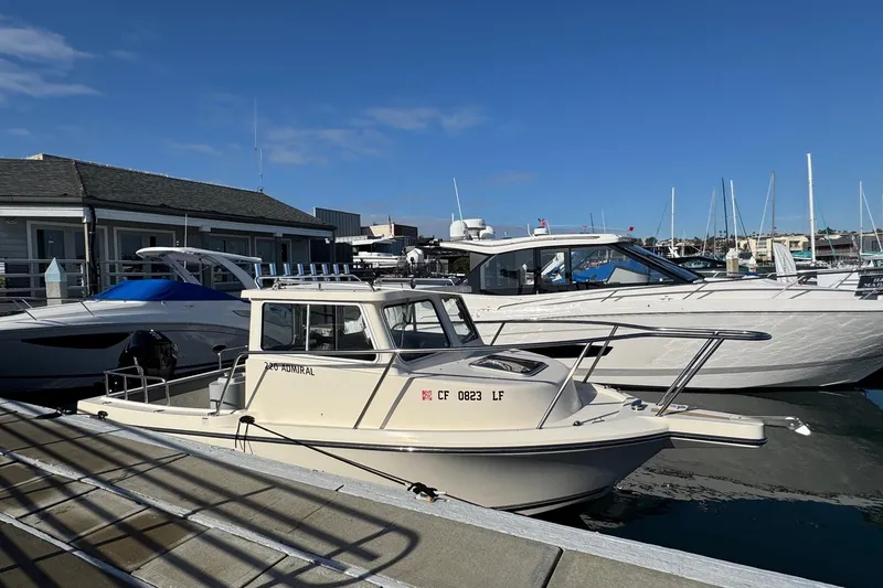 Slide: The Image of 2023 Defiance Admiral 220 EX boat docked at marina under clear blue sky. - 9