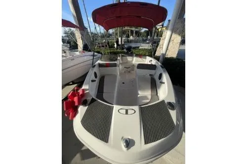 Slide: The Image of 2024 Tahoe T16 boat with red canopy, docked outdoors. - 2