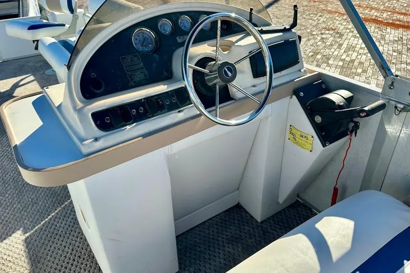 Slide: The Image of 2004 Crest 2200 Family DL boat dashboard with steering wheel and control panel. - 23