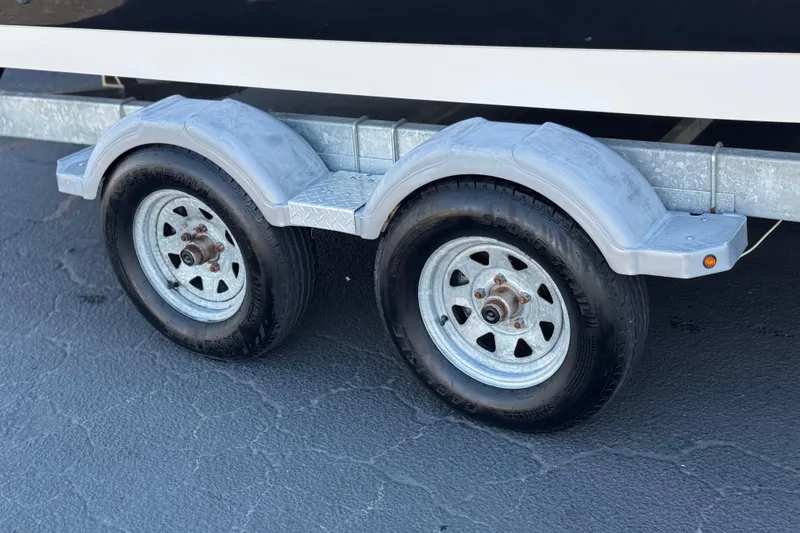 Slide: The Image of Trailer wheels of a 2021 Trophy T21 Bay boat on a paved surface. - 22