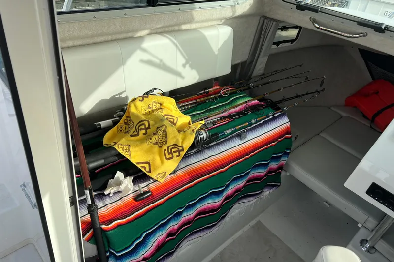 Slide: The Image of Interior of 2022 Parker 2320 Sport Cabin with fishing rods and colorful blanket. - 11
