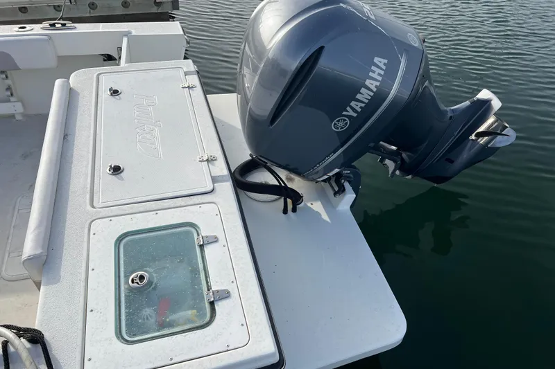 Slide: The Image of 2022 Parker 2320 Sport Cabin with Yamaha outboard motor on calm water. - 13