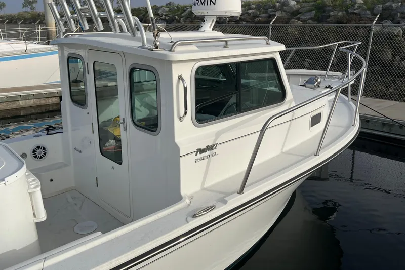 Slide: The Image of 2022 Parker 2320 Sport Cabin boat docked at marina, side view. - 2