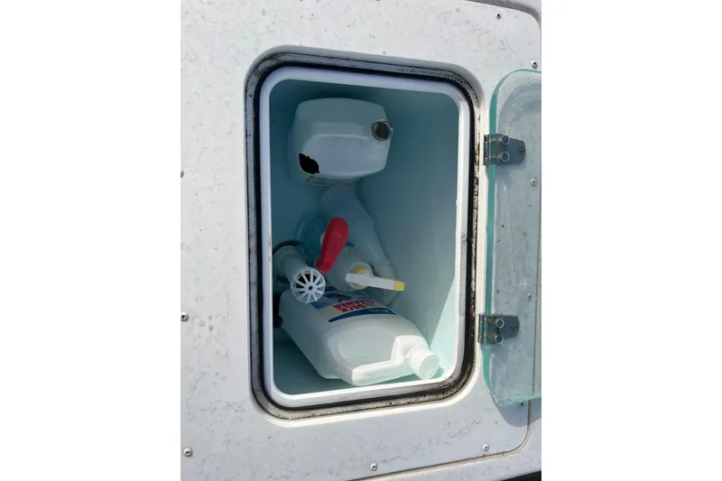 Slide: The Image of Storage compartment on a 2022 Parker 2320 Sport Cabin boat with cleaning supplies. - 20