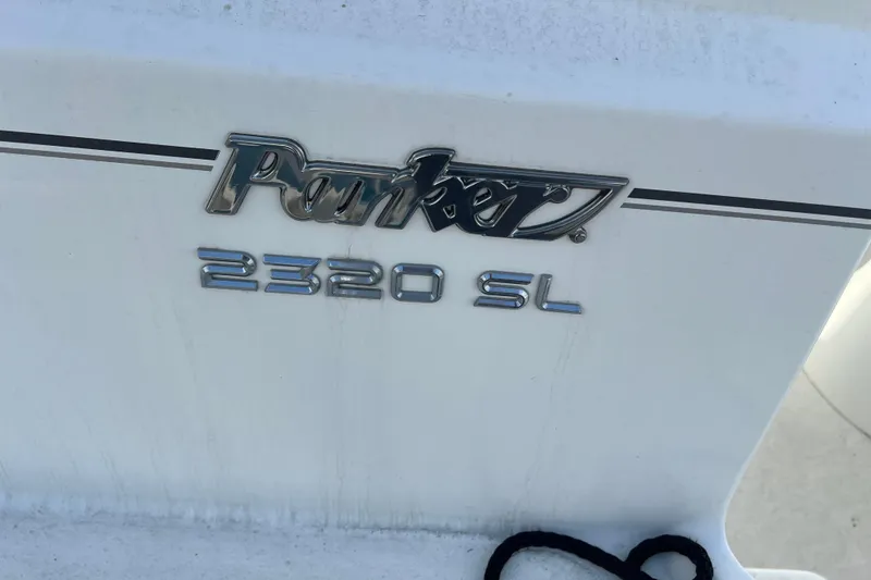 Slide: The Image of 2022 Parker 2320 Sport Cabin boat emblem on white surface. - 23