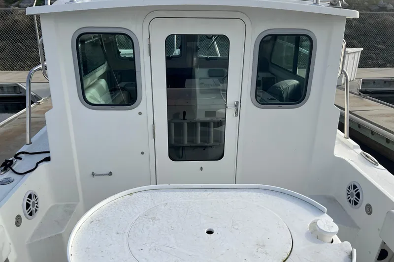 Slide: The Image of 2022 Parker 2320 Sport Cabin boat at dock, rear view of cabin and deck. - 4