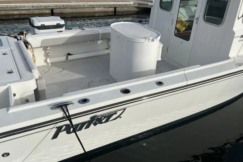 Slide: The Image of 2022 Parker 2320 Sport Cabin boat docked, showcasing spacious deck and cabin features. - 6