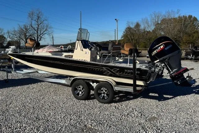 The Image of 2026 Xpress H22B Bay boat on trailer with Yamaha outboard motor, parked on gravel. - 1