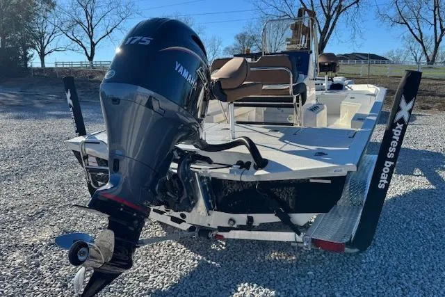Slide: The Image of 2026 Xpress H22B Bay boat with Yamaha 175 engine, parked on gravel. - 2
