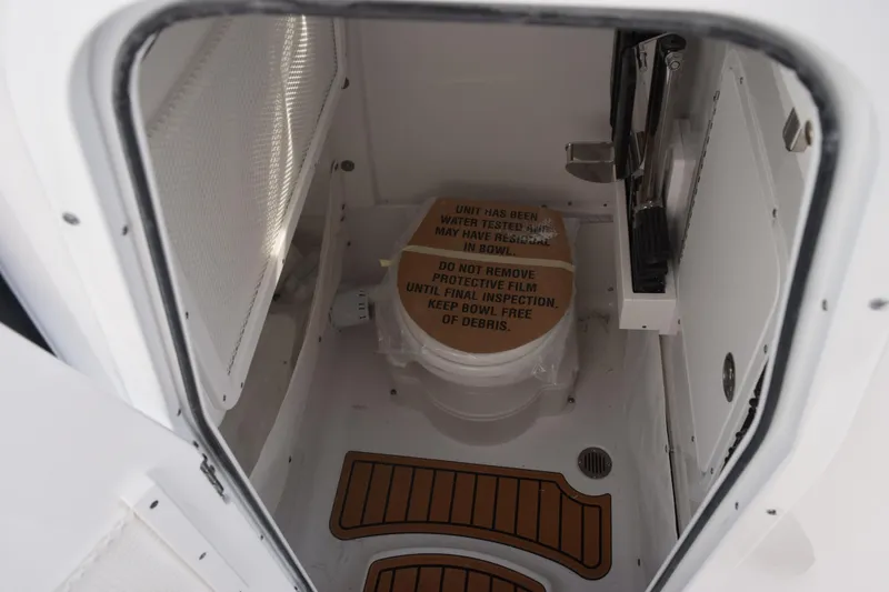 Slide: The Image of 2026 Sea Hunt Ultra 255 SE boat interior with protective film on toilet. - 16