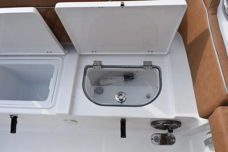Slide: The Image of 2026 Sea Hunt Ultra 255 SE boat storage compartments with brown seating. - 25