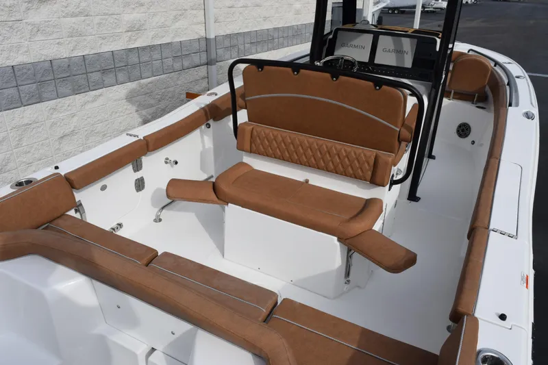 Slide: The Image of 2026 Sea Hunt Ultra 255 SE boat interior with brown cushioned seating and Garmin displays. - 6