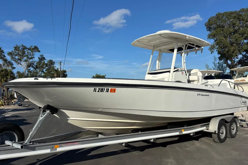 Slide: The Image of 2015 Boston Whaler 270 Dauntless boat on trailer under clear blue sky. - 1