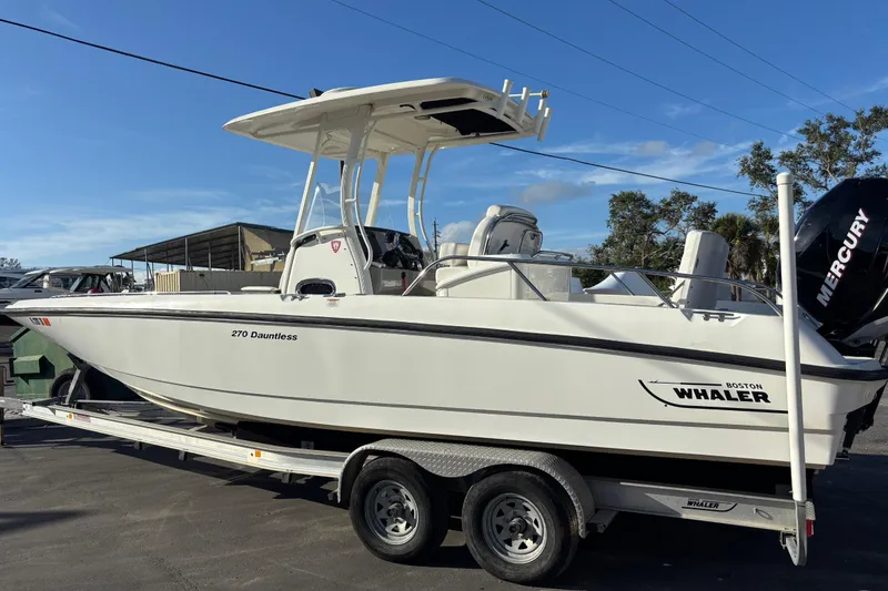 Slide: The Image of 2015 Boston Whaler 270 Dauntless boat on trailer, side view, clear sky background. - 2