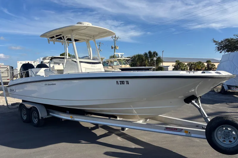 Slide: The Image of 2015 Boston Whaler 270 Dauntless boat on trailer under clear blue sky. - 3