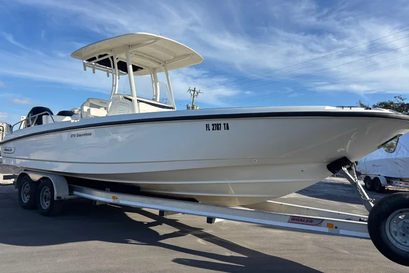 Slide: The Image of 2015 Boston Whaler 270 Dauntless boat on trailer under clear blue sky. - 4