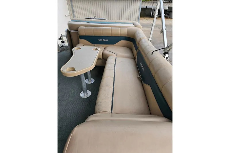 Slide: The Image of 2004 Parti Kraft Admiral 240 RE pontoon boat interior with beige seating and table. - 3